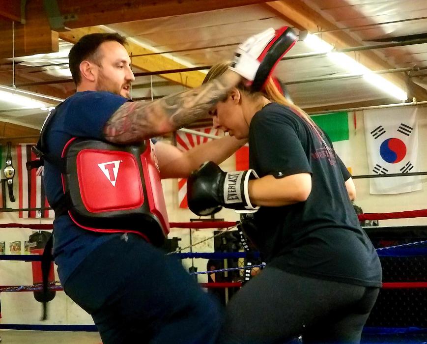 Photos by Brett Fisher. Nick Artam teaches a client self-defense techniques in the sparring ring at Tazmanian Boxing Club.