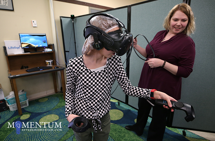 Mineral County Library Assistant Director Kathy Kachelries talks to Shawna Clark, 11, as she explores virtual reality.
