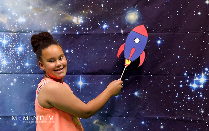 Bailey Ellsworth, 7, poses in the photo booth during the Carson City Library’s Summer Learning Challenge kick off Saturday.
