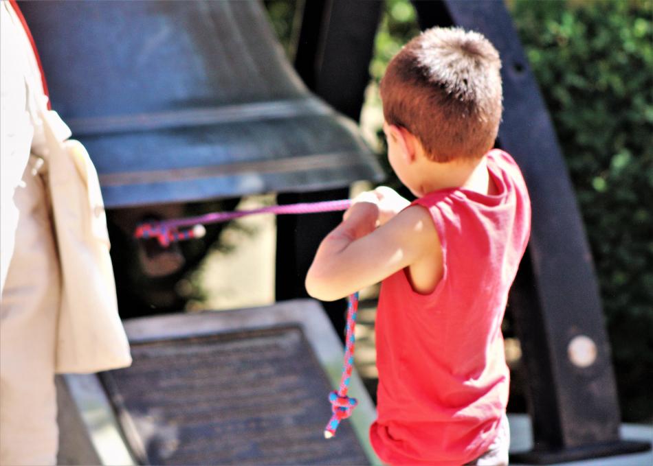 A youth pulls on the rope to ring the heavy Liberty Bell.