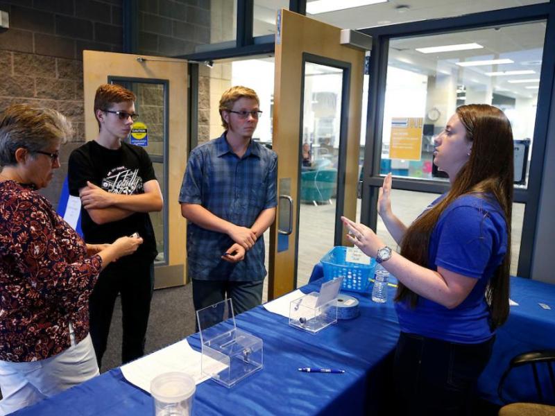 Sierra Montana, a WNC scheduling coordinator talks with Jackie Blaha and her sons, Connor and Dakota during community night.