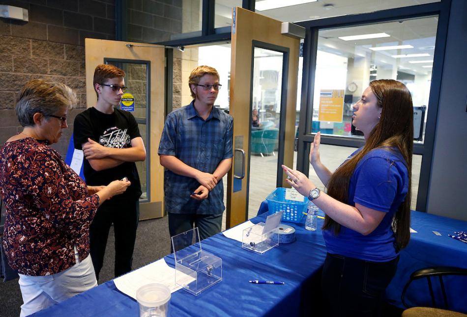 Sierra Montana, a WNC scheduling coordinator talks with Jackie Blaha and her sons, Connor and Dakota during community night.