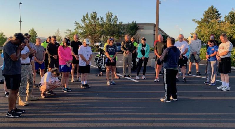 Participants bow their heads in a moment of silence before the run