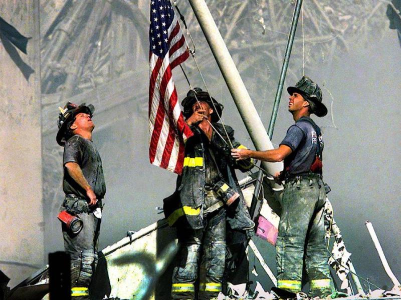 AP File Photo. FDNY firefighters raise the American Flag amidst the rubble of the World Trade Center.