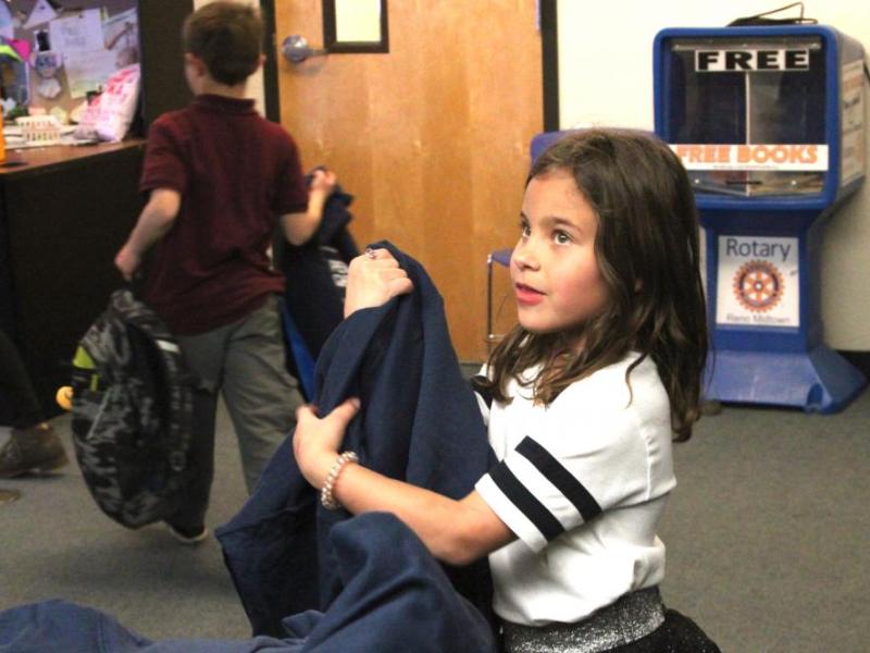 A member of the Boys & Girls Clubs of Western Nevada receives her new sweatshirt at the Club’s annual Christmas party.