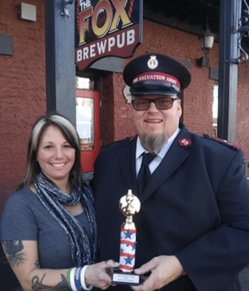 Jamie Waterman, GM of The Fox Brewpub receives the Battle of the Bars Turkey winning trophy by Capt. Mark Cyr.