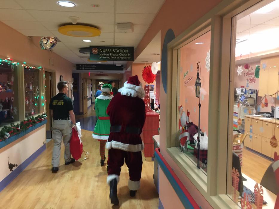 Santa and his helpers walk through hallway of the pediatric ward at Carson Tahoe Hospital.