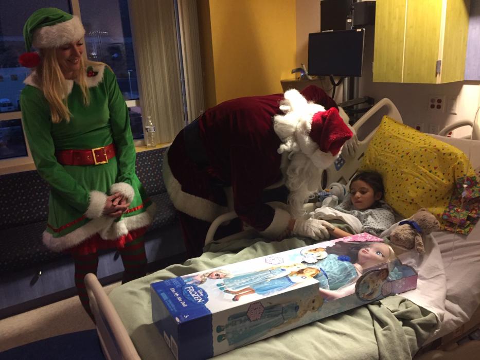 Santa Nick and Karen Jessop give 7-year-old Brisa, a patient at Carson Tahoe Hospital, a Elsa doll during their visit.