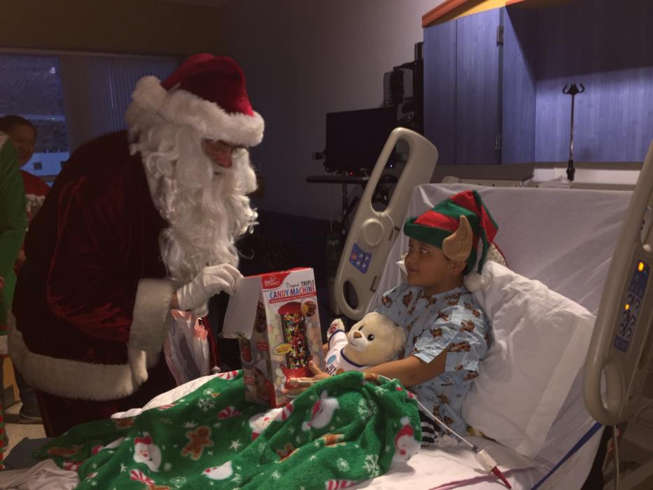 Santa Nick gives Carson Tahoe Hospital patient Lorenzo, 7, a gift on Christmas Eve.