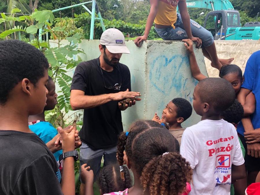 Sierra Lutheran High School alumn Taylor Love ('08) teaches a class on soil to Panamanian children at the non-profit Give & Surf