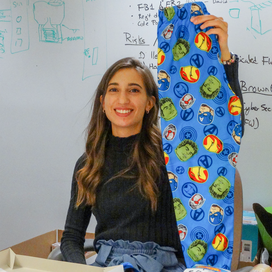 Electrical Engineer Gabriella Kobany holds up a pair of children's pants she's wrapping.
