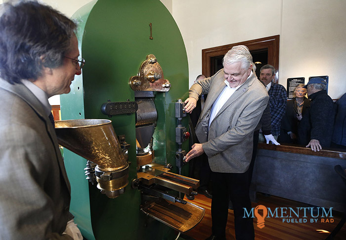 Nevada Gov. Steve Sisolak, right, strikes a commemorative sesquicentennial medallion during the celebration.