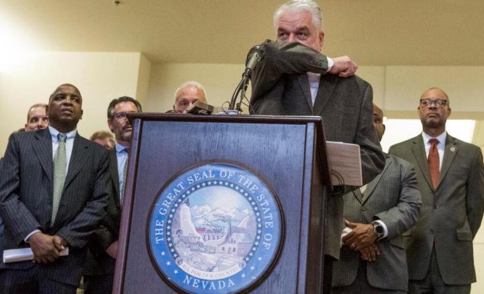 Gov. Steve Sisolak demonstrates how to cover while sneezing during a Feb. 28 news conference. Jeff Scheid/Nevada Independent
