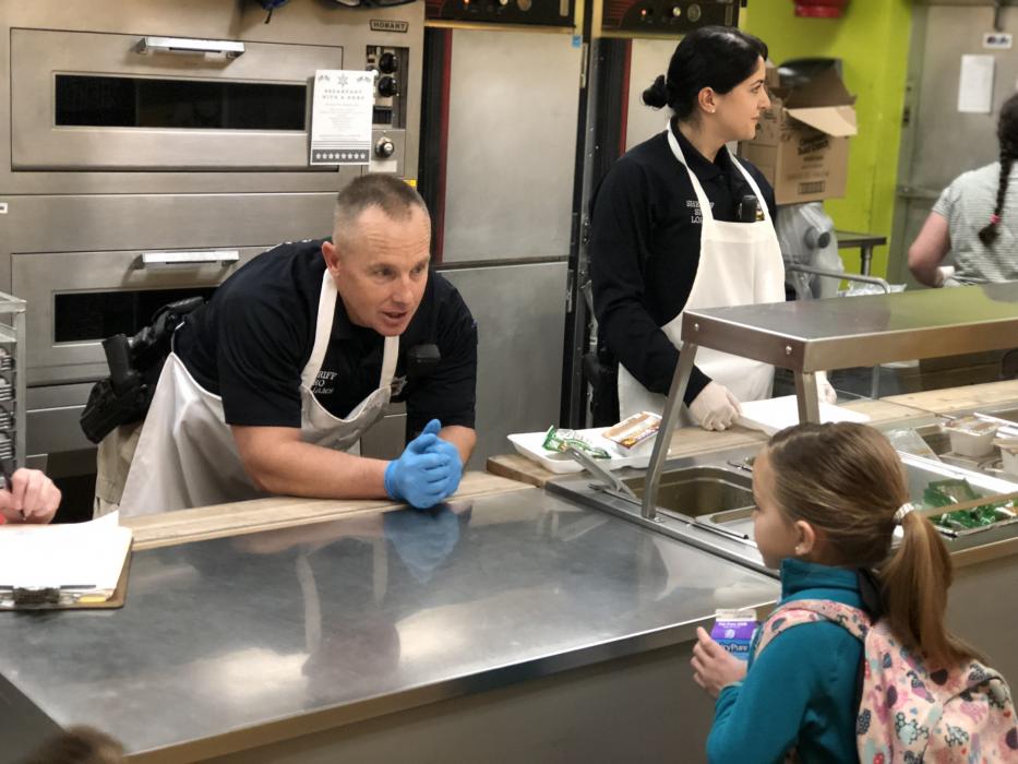 School Resource Officers Dean Williams and Liz Lopez serve breakfast to grade schoolers last year.