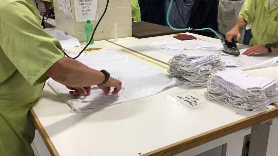 Part of the process for making masks involves attaching draw strings and ironing them to the fabric.