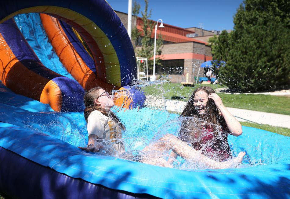 Addison Fredeen, left, and Haley Mangone enjoy a bouncy house at a WNC BBQ in 2018.