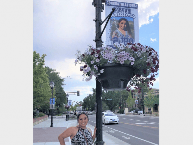 CHS 2020 graduate Gabi Avina stands under the banner sporting her photo.