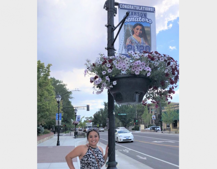 CHS 2020 graduate Gabi Avina stands under the banner sporting her photo.