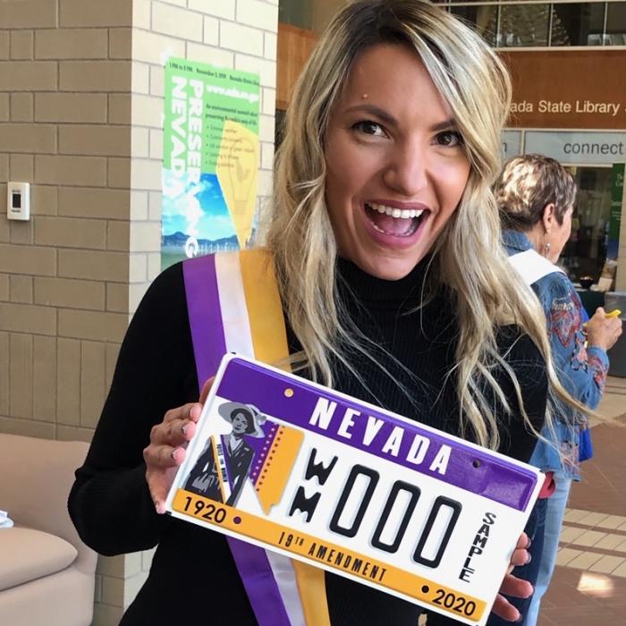 WNC graphic design student Maxine Thew displays the specialty women’s suffrage license plate that she helped design.