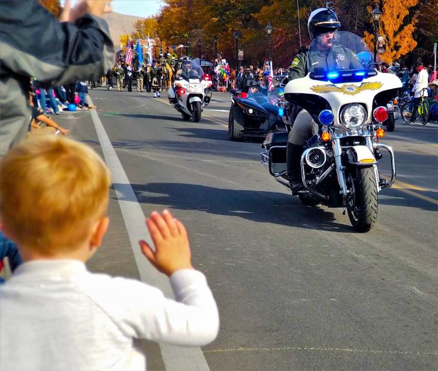 Photos by Brett Fisher. A little boy waves to a Carson City motor officer during the 2018 Nevada Day Parade.