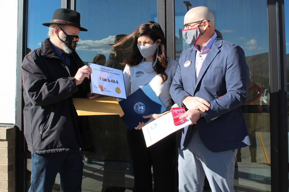 Carson City Chamber Chair Rob Joiner presents the owners with membership materials and congratulations.