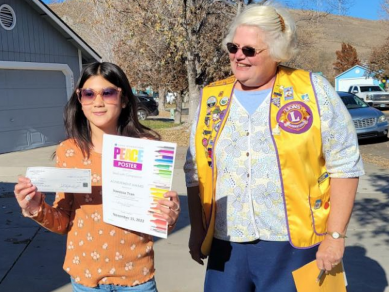 Lion President Terry Rubald presents Peace Poster Contest Winner Vanessa Tran with a $50 prize and Certificate of Achievement