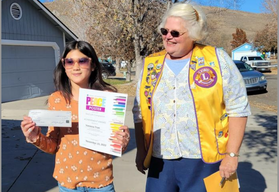 Lion President Terry Rubald presents Peace Poster Contest Winner Vanessa Tran with a $50 prize and Certificate of Achievement
