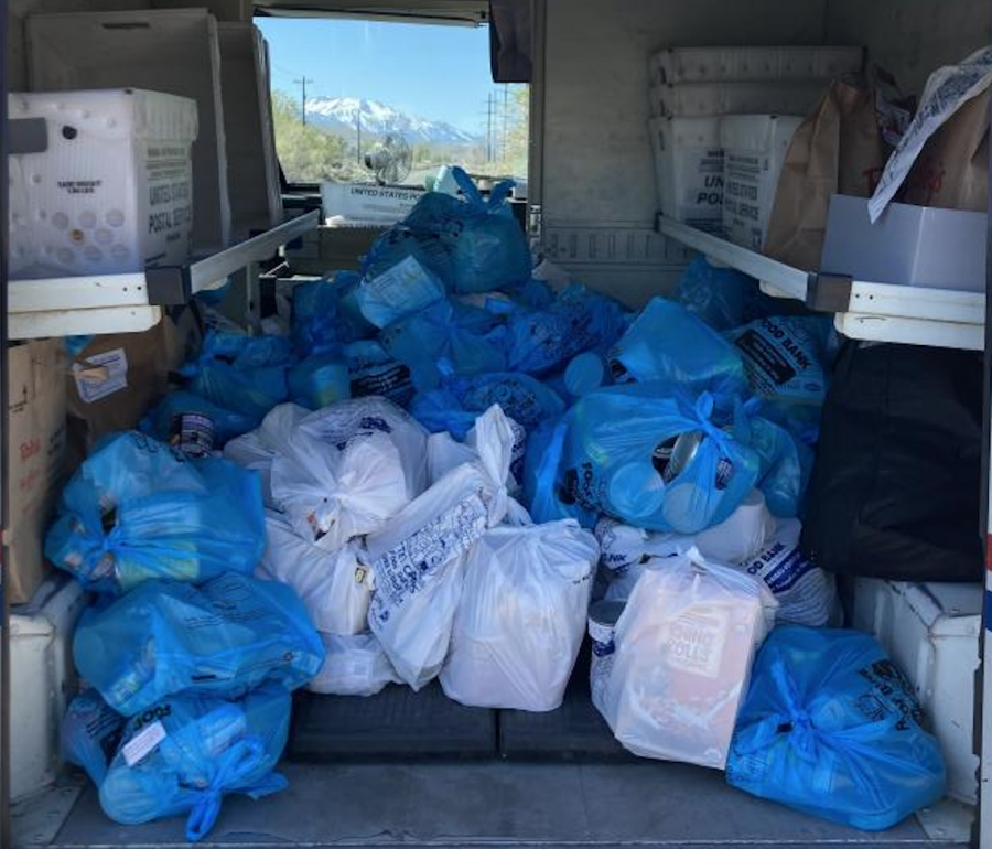 Food donations fill the back of mail truck.