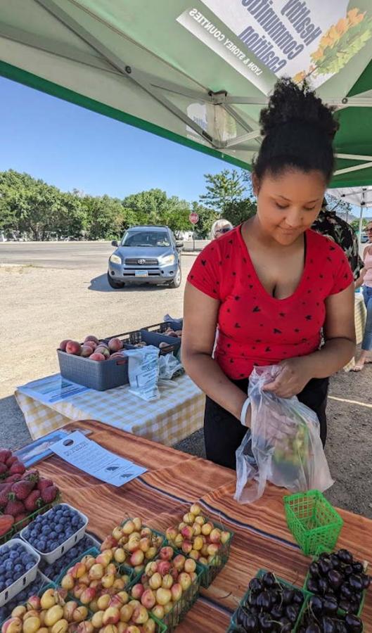 Aribella Payne helps customers at the Thursday Dayton Farmers Market