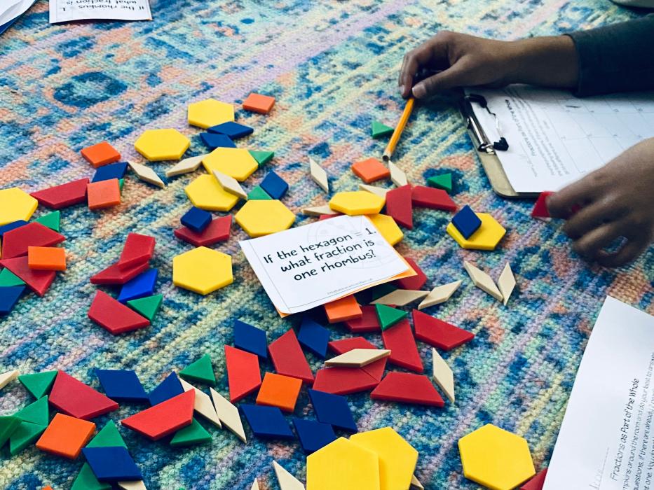 Students engage in symmetry and fraction tasks using pattern blocks.