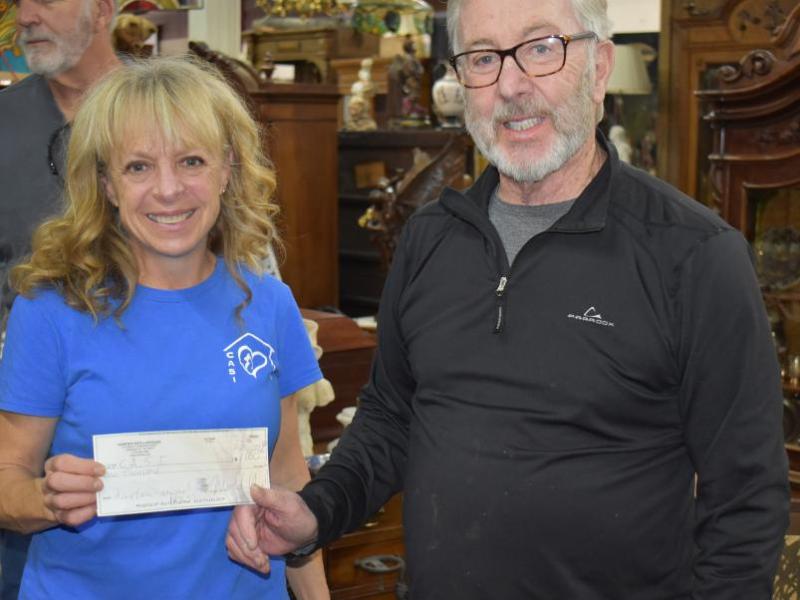 Michael  Robbins owner of Hanifin's Antiques presents a check for $1000 to help fund CASI.