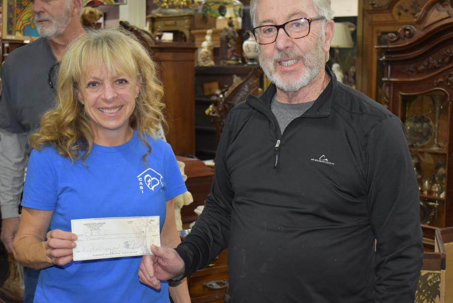 Michael Robbins owner of Hanifin's Antiques presents a check for $1000 to help fund CASI.