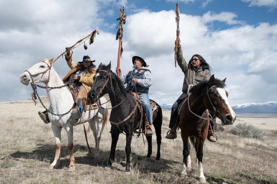 Prayer horse riders, from left, Rusty Brady, Josh Dini and Gary McKinney, raise their prayer staffs after reaching Sentinel Rock