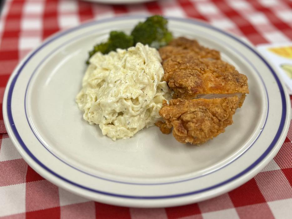 Breaded fried chicken with alfredo linguini and steamed broccoli.