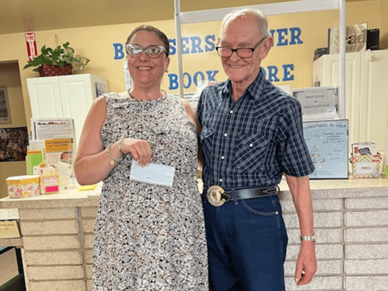 Joy Holt, Carson City Library Director receives a large donation from Phil Patton, Treasurer of Friends of the CC Library.