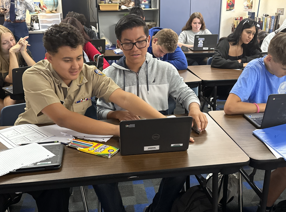 Students of Spence work together on a laptop to finish their group assignment